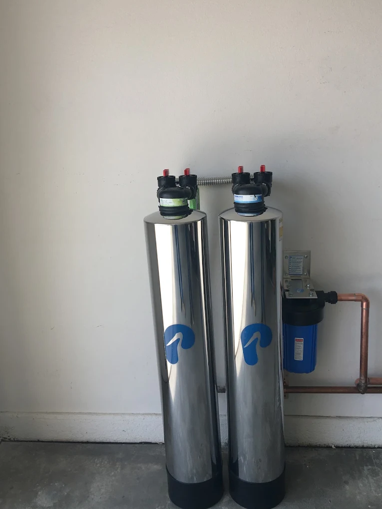 Whole-house water filtration and softener tanks installed in a garage